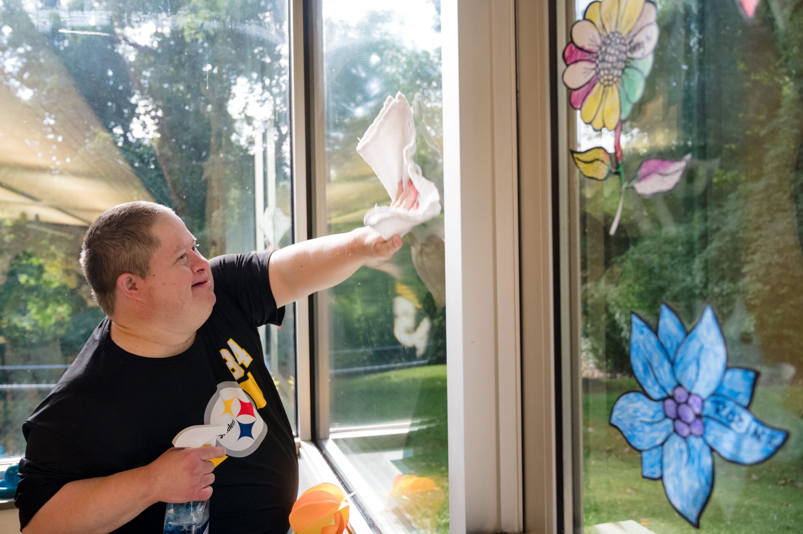 A gentleman smiling and cleaning windows