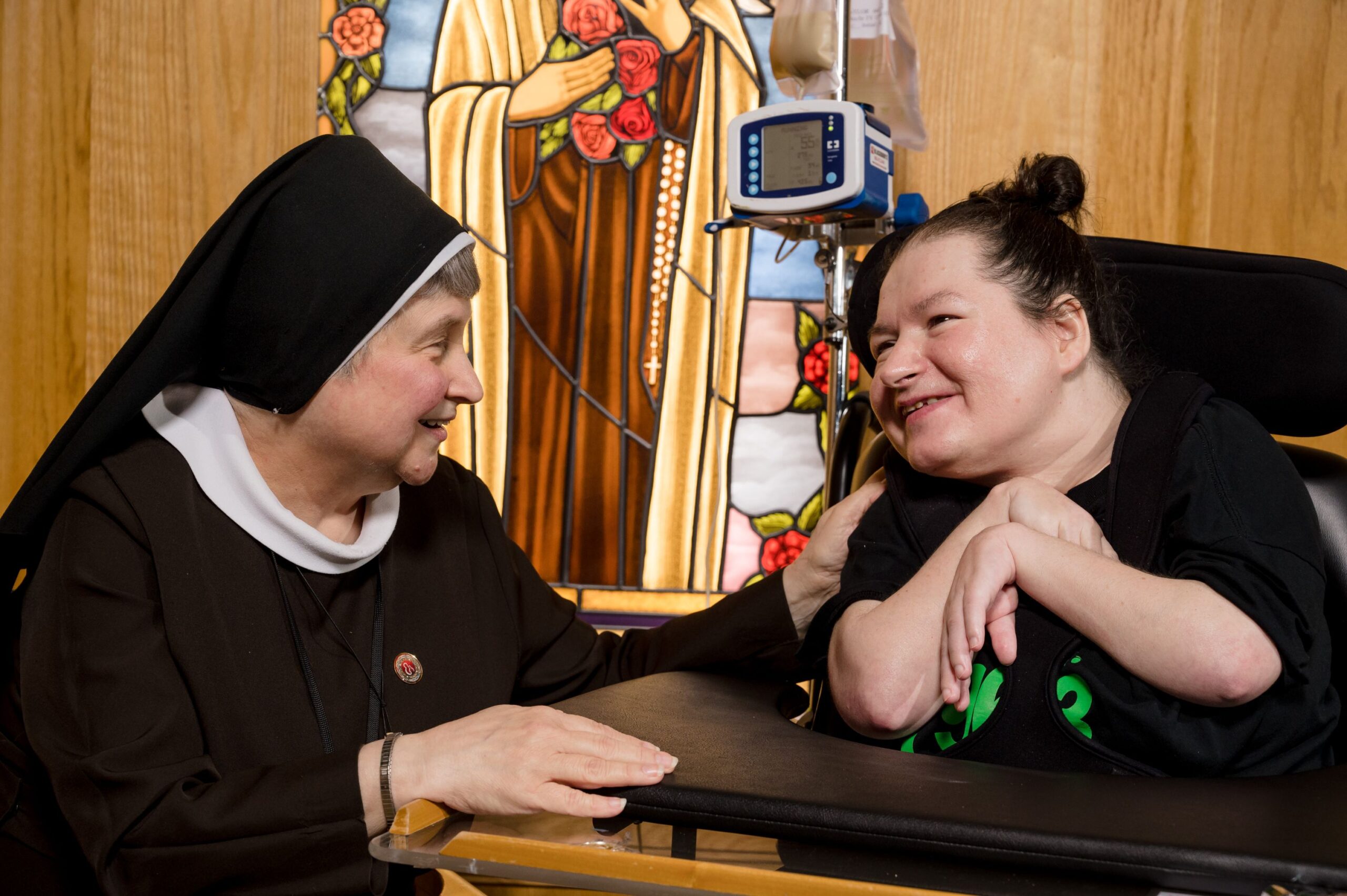 A nun and a resident in the chapel at McGuire Memorial. 