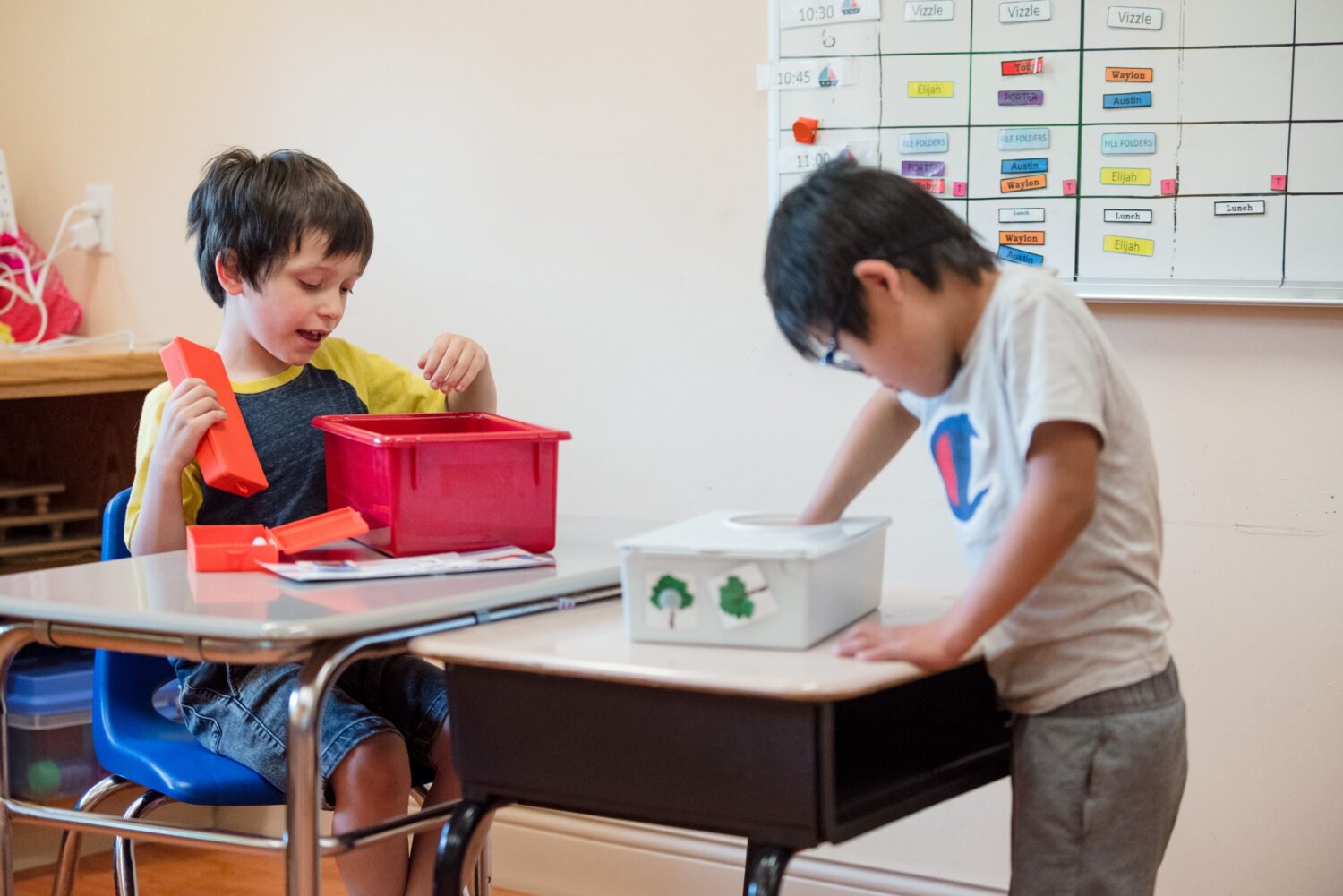 Two young students in a classroom working on an activity. 
