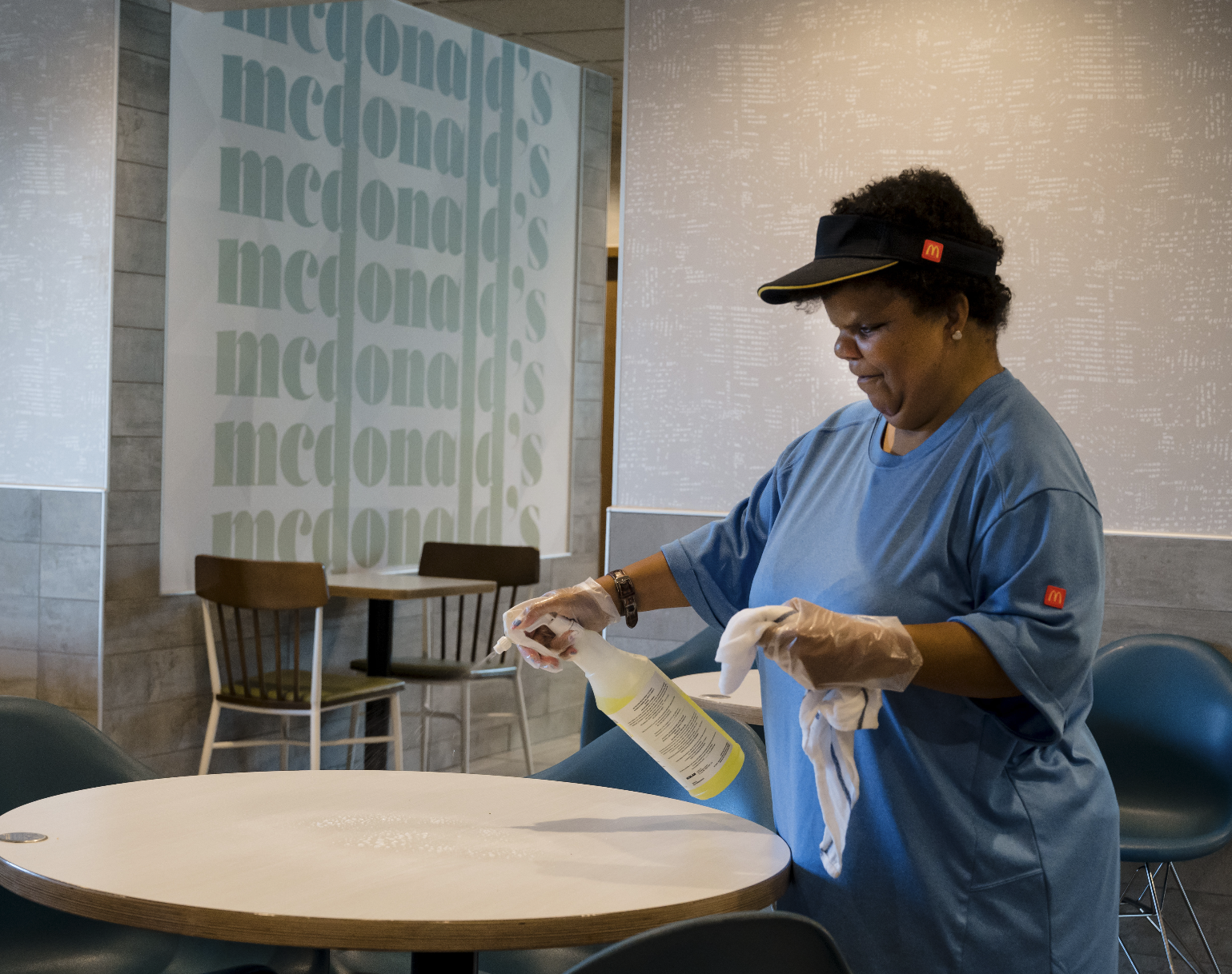 A female McDonald's employee cleaning a table